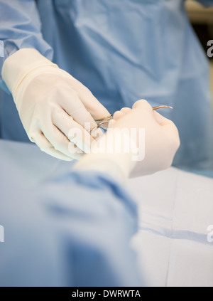 Surgeons Passing Scissors During Surgery Stock Photo