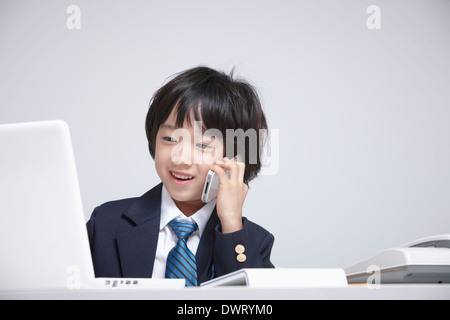 a kid wearing a business suit making a call Stock Photo