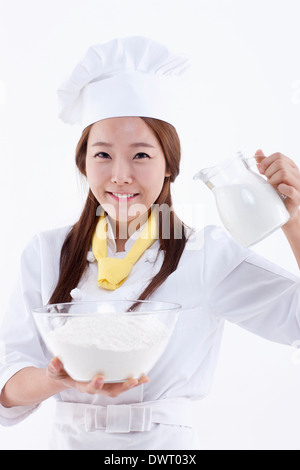 a female pastry chef holding a jar of milk