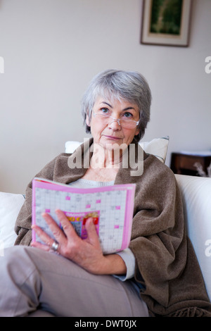 Elderly person doing cr-word puzzle Stock Photo