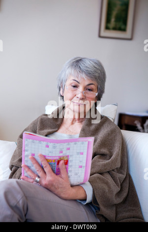 Elderly person doing cr-word puzzle Stock Photo