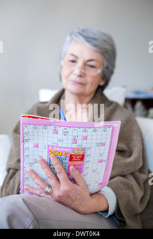 Elderly person doing cr-word puzzle Stock Photo