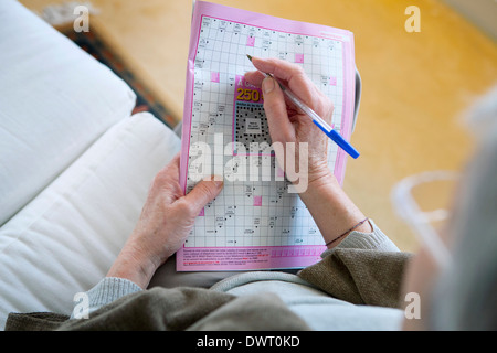 Elderly person doing cr-word puzzle Stock Photo