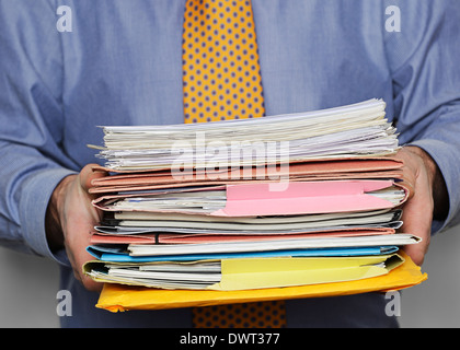 Overworked Businessman Carrying a Stack of Paperwork. Close Up. Stock Photo