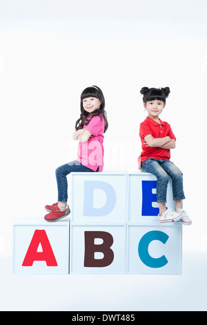 kids sitting on alphabet blocks Stock Photo - Alamy