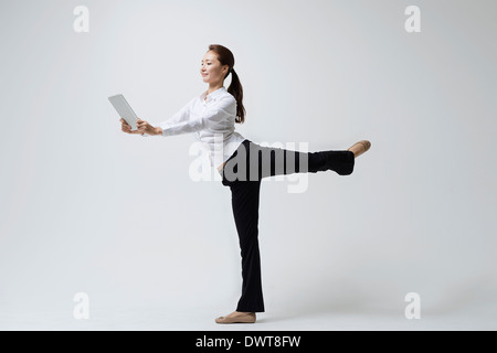 a woman making dance poses with a laptop Stock Photo