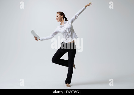 a woman making dance poses with a laptop Stock Photo