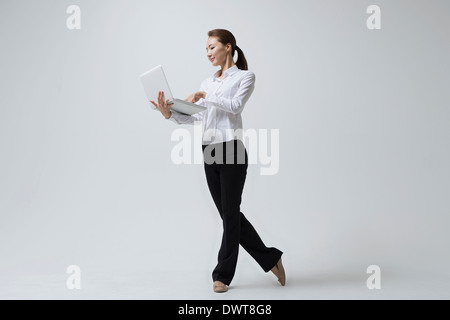 a woman making dance poses with a laptop Stock Photo