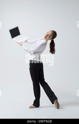 a woman making dance poses with a laptop Stock Photo