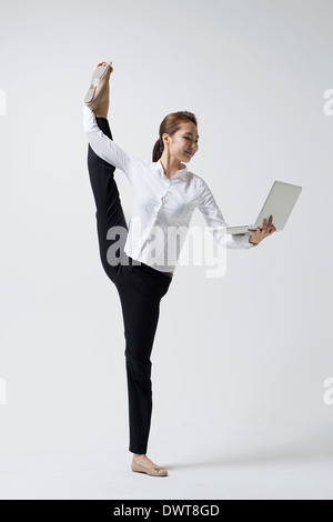 a woman making dance poses with a laptop Stock Photo