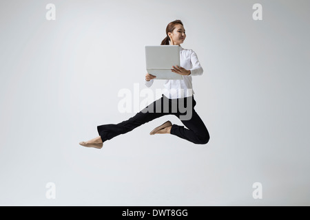 a woman making dance poses with a laptop Stock Photo