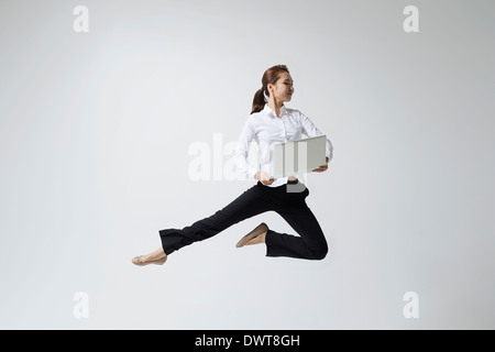 a woman making dance poses with a laptop Stock Photo