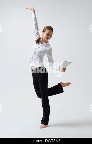 a woman making dance poses with a laptop Stock Photo