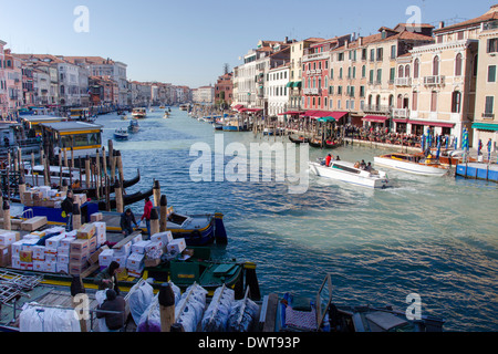 Canal barges unload supplies for merchants along the Grand Canal on a beautiful morning. Stock Photo