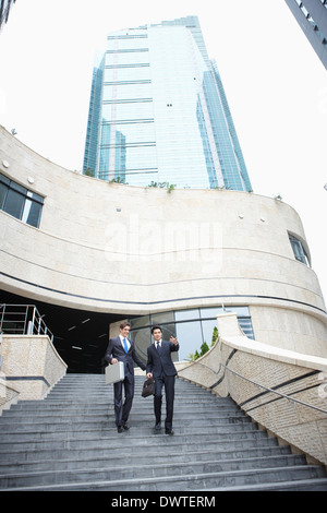 two business men walking the stairs together Stock Photo