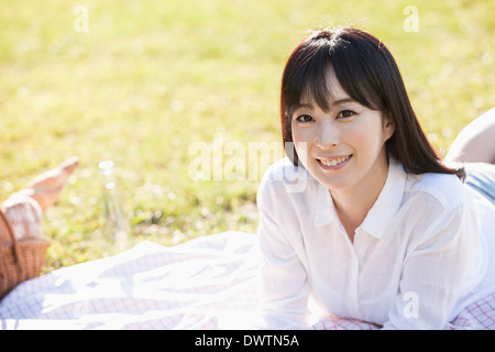 a woman reading a book on the grass Stock Photo