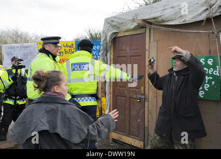 Policewoman stands in front of a protester to protect him from a TAU officer who pushed him violently into the wooden shed. Stock Photo