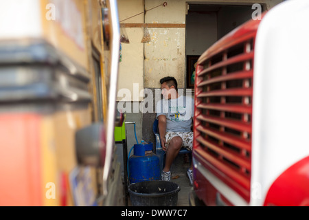 An attendent at the bus terminal laughs and jokes in the mountain town of Juayua on the rutas de la flores in El Salvador Stock Photo