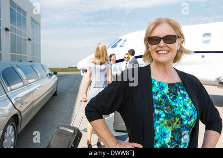 Happy Businesswoman Against Private Jet Stock Photo