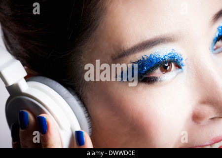 a woman with a head set and heavy blue make up Stock Photo