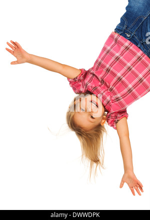 Happy 4 years old girl hanging upside down isolated on white with smile on her face Stock Photo