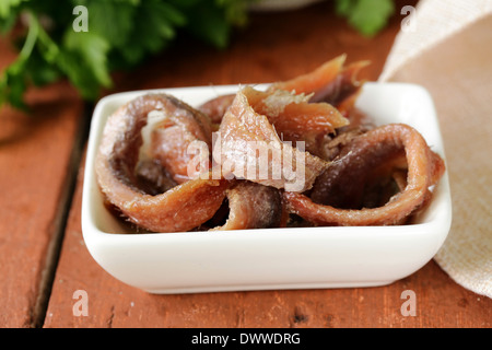 Canned marinated anchovies fillets in a white bowl Stock Photo