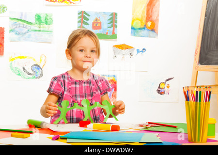 Little four years old girl holding garland made of paper in art class in kindergarten Stock Photo