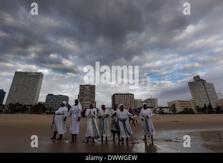 Woman sing as while they wait their turn to be baptised in the Indian Ocean on the Durban beach front, March 28, 2010. © Rogan Stock Photo