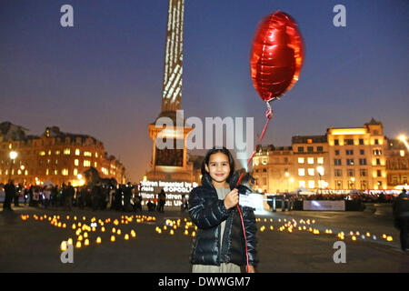 London, UK. 13th March 2014. 7 year old Sophia Lileh Petteni with a a red balloon. Banksy artwork of a Syrian girl with a balloon was projected onto Nelson's Column at  the Stand With Syria Rally, Trafalgar Square, London to mark the third anniversary of the crisis in Syria. Credit:  Paul Brown/Alamy Live News Stock Photo