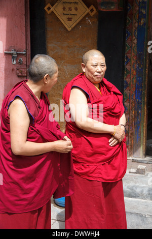 Two Tibetan nuns near the Tsamkhung (or Canggu) Nunnery, the only Buddhist nunnery in the old city of Lhasa, Tibet Stock Photo