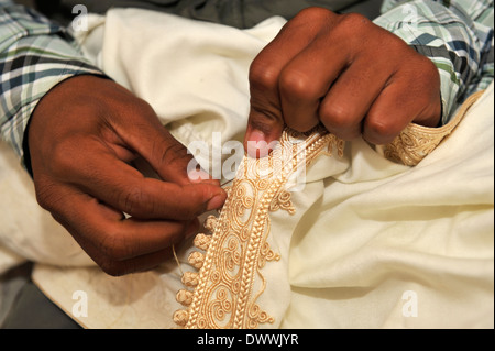 Close-up details of traditional hand stitching the 'buttons' on summer light weight kaftan robe, Marrakech, Morocco Stock Photo