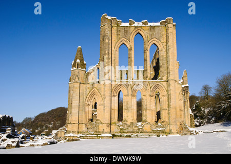 The ruins of Rievaulx Abbey under a heavy covering of snow on a bright winter's morning in the North York Moors National Park. Stock Photo