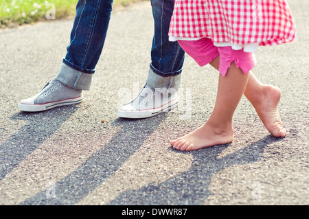 Low section of boy and girl (6-9) standing on road Stock Photo