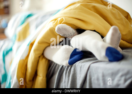 Feet of young couple lying in bed Stock Photo