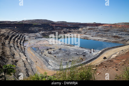 A massive open cast copper and gold mine in Africa.  Drill rigs in the bottom corner are drilling a blast pattern. Stock Photo