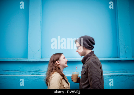 USA, Massachusetts, Young couple face to face, blue wall in background Stock Photo