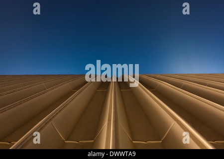 Golden rooftop of a hall with blue sky background Stock Photo