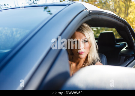 Young blond woman portrait in a car. Stock Photo