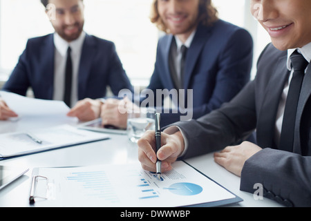 Young businessman working with spreadsheet with his colleagues on background Stock Photo