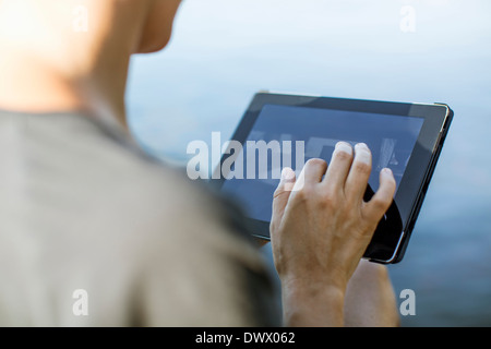 Cropped image of woman touching digital tablet outdoors Stock Photo