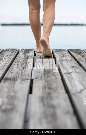 Low section of woman walking on pier Stock Photo