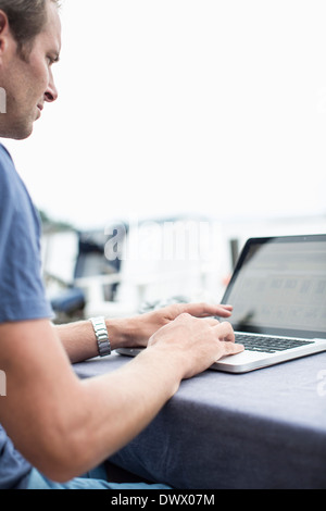Man using laptop outdoors Stock Photo