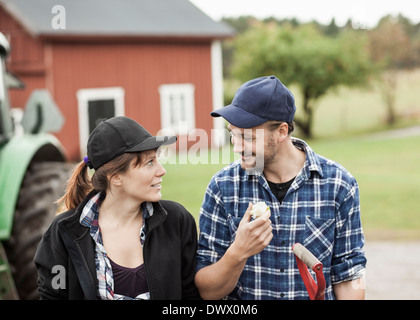 Mid adult couple looking at each other on farm Stock Photo