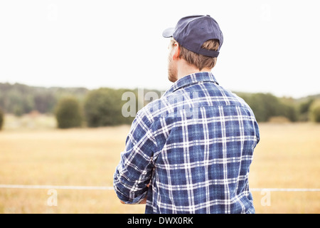 Rear view of farmer standing in the field Stock Photo - Alamy