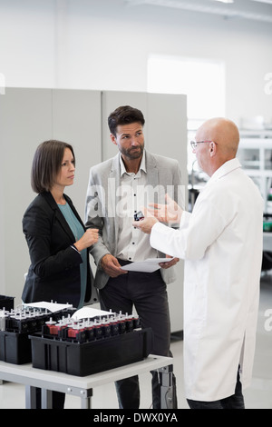 Engineer explaining machine part to business people in industry Stock Photo