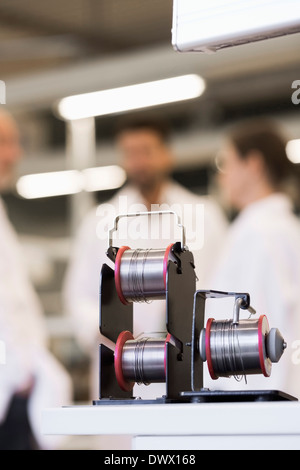 Spools of wire with engineers in background at manufacturing industry Stock Photo