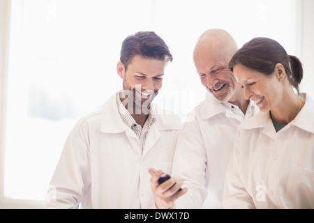 Happy engineers using mobile phone in manufacturing industry Stock Photo