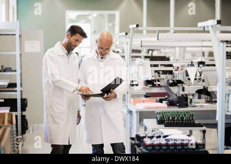 Male engineers discussing over file in industry Stock Photo