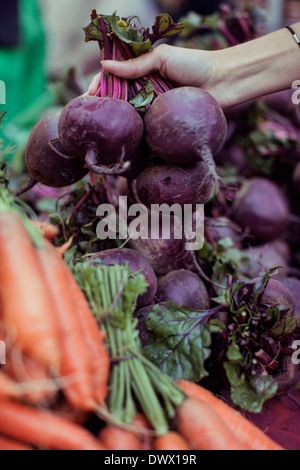 Cropped image of woman buying beets at vegetable stall Stock Photo