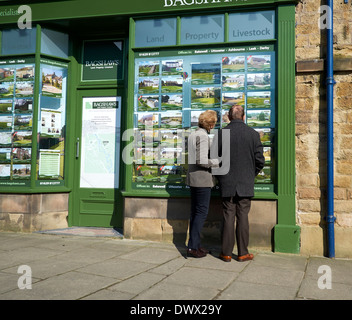 A middle aged couple looking at an estate agents window bakewell Derbyshire England uk Stock Photo